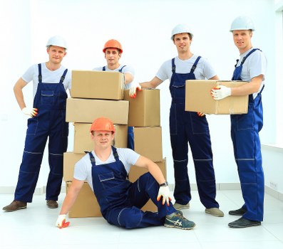 Moving team handling furniture on a residential street in Gospel Oak